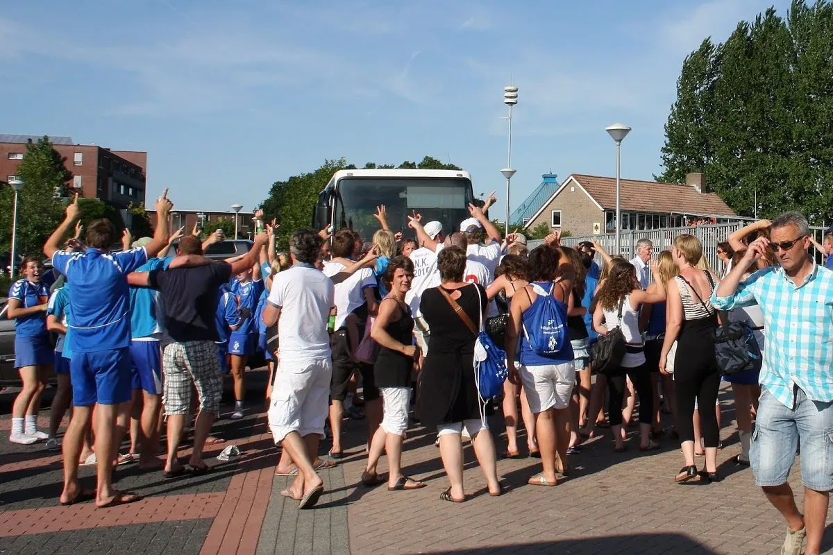 Leden vieren samen feest buiten, bij een bus