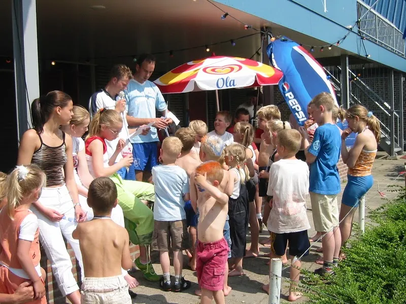 Kinderen staan in de zomer rond de ijskar bij het clubhuis
