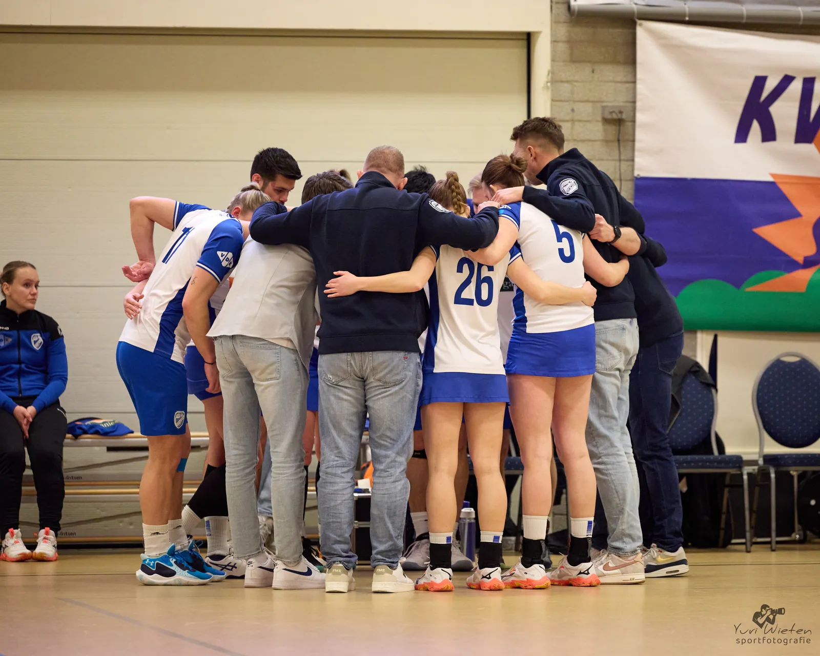 De selectie van Wit-Blauw staat in een kring voor de wedstrijd